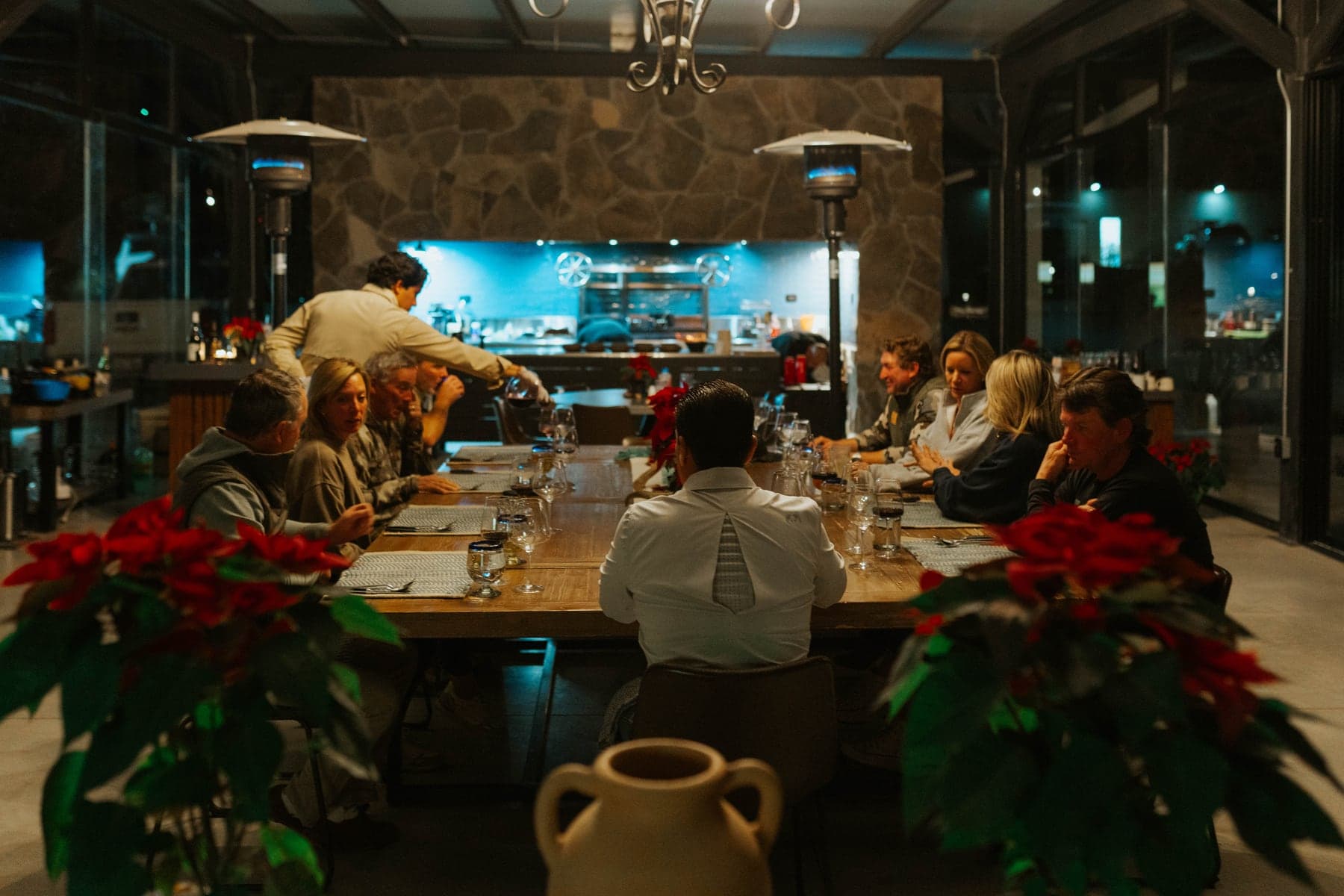 The glass-walled communal dining hall with an open kitchen and set tables